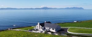 an aerial view of a house on a hill next to the water at Ballyheigue Cliff Side and Sea View Apartment in Ballyheigue