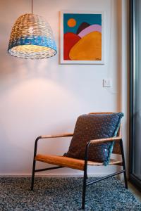 einen Stuhl in einem Zimmer mit Gemälde und Lampe in der Unterkunft Art District - POP & ROCK Apartments in Porto