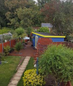un jardín con un cobertizo colorido y una terraza en Mango Lodge, en Kent