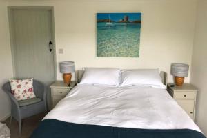 a bedroom with a bed and a picture on the wall at Coach House in Weedon