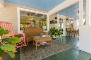 eine Veranda mit einem Sofa, Stühlen und einem Tisch in der Unterkunft Key West Villas in Key West