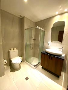 Un baño con ducha, inodoro y lavabo. en Eleonora Hotel Apartments, en Lárnaca