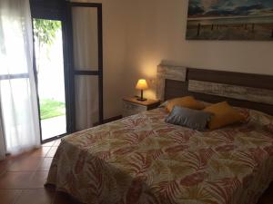 ein Schlafzimmer mit einem Bett mit einer Lampe und einem Fenster in der Unterkunft Casa Ananda y Casa Rengue in Conil de la Frontera