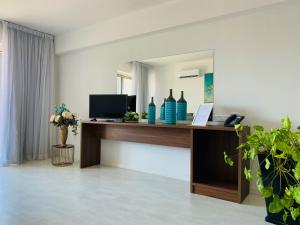 ein Büro mit einem Schreibtisch und einem Spiegel in der Unterkunft Eleonora Hotel Apartments in Larnaka