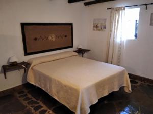 a bedroom with a bed in a room with a window at Posada Matadero in Cortelazor