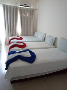 Pousada Rekinty في كانيندي دي ساو فرانسيسكو: سريرين في غرفة مع مناشف حمراء وزرقاء