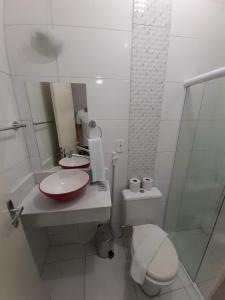 a bathroom with a toilet and a sink and a mirror at Pousada Rekinty in Canindé de São Francisco