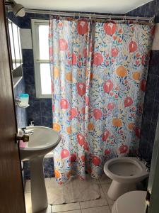 a bathroom with a shower curtain with a toilet and a sink at Apartamento Pacifico Suites Centro in Bahía Blanca +20 photos