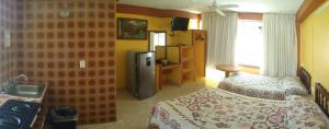 a room with a bedroom with a bed and a refrigerator at Hotel Olimar in Acapulco