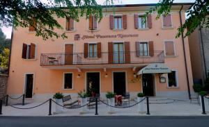 a pink building with a sign on the front of it at Hotel Panorama Ristorante ***S in Torri del Benaco
