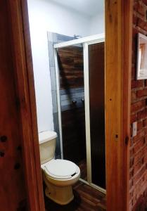 a bathroom with a white toilet in a room at Cabañas las Alazanas in Mazamitla