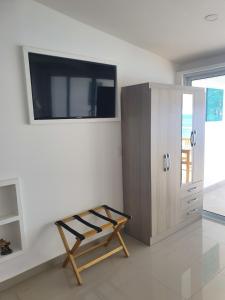 Sabana WestpuntにあるBlue View Apartmentsのテレビ、棚、キャビネットが備わる客室です。