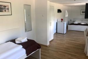 a white room with two beds and a refrigerator at Pension Rote Rosen in Seesen