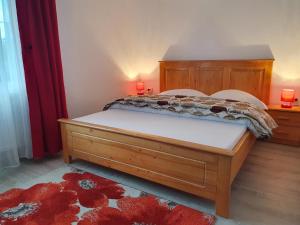 a bedroom with a bed with a wooden headboard at Pensiunea Ronicson in Miloştea