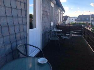 patio con mesa y sillas en el balcón en Pension Rote Rosen, en Seesen