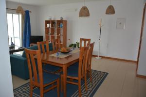 y sala de estar con mesa de comedor y sillas. en Apartamento de Vila Franca do Campo, en Vila Franca do Campo