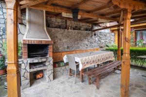 a patio with a table and an outdoor oven at Guest House Roden Dom in Koprivshtitsa