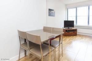 a dining room with a table and chairs and a television at Apartment 12 Popeshead Court in York