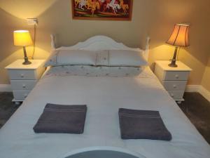 a large white bed with two nightstands and two lamps at Pat Tadys in Manorhamilton