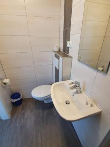 a bathroom with a white sink and a toilet at Gästehaus am Heuss-Platz in Erlangen