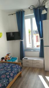 um quarto com uma cama e uma janela com cortinas azuis em Appartement 2 chambres 52 m2 centre ville em Vendôme