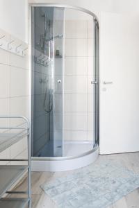 a shower with a glass door in a bathroom at Hostel Zakątek ulica Grunwaldzka in Bielsko-Biała