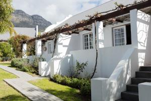 a white house with mountains in the background at Church Hills Boutique Accommodation in Riebeek-Wes