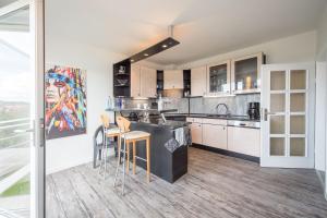 - une cuisine avec un comptoir et quelques chaises dans l'établissement Weitblick-Ferienwohnung, à Eisenach