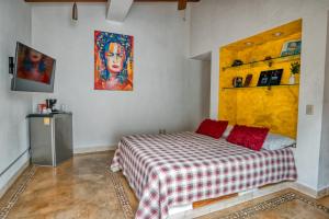 a bedroom with a bed and a painting on the wall at Hacienda Alemana Hotel Boutique in Puerto Vallarta