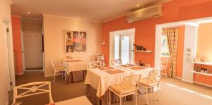 a room with two tables and chairs and orange walls at Church Hills Boutique Accommodation in Riebeek-Wes