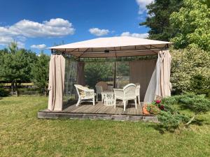 cenador con mesa y sillas en la terraza en Galikowo, en Płaska