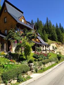 a house with a garden in front of it at Apartments Vučko Vlašić in Vlasic