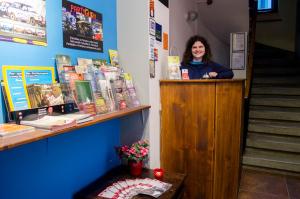 a woman standing at a podium in a book store at Red Nose Hostel with Self-Check In in Riga