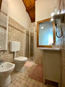 La salle de bains est pourvue de toilettes, d'un lavabo et d'une télévision. dans l'établissement Il Canto Del Gallo B&B, à Zenson di Piave