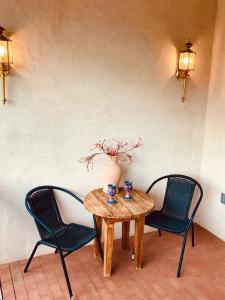 Dos sillas y una mesa de madera con un jarrón. en Guadalupe Inn, en Santa Fe