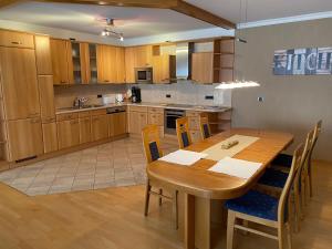 a kitchen with a wooden table and wooden chairs at Ferienwohnung Kunstmeile in Oberhausen