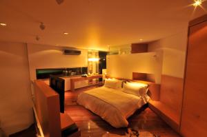 a bedroom with a large bed and a bathroom at AcquaSanta Lofts Hotel in Cali