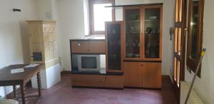 a room with a tv and a wooden cabinet at Appartamento Lorenzoni - Stella Alpina in Croviana +1 photo