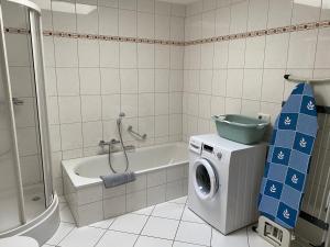 a bathroom with a washing machine and a washer at Ferienwohnung Kunstmeile in Oberhausen