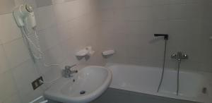 a white bathroom with a sink and a shower at Appartamento Lorenzoni - Stella Alpina in Croviana