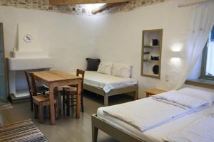 Habitación con 2 camas, mesa y escritorio. en Ghermaniko Guesthouse, en Damouchari