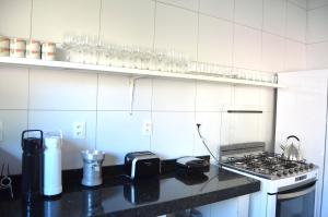 a kitchen with a stove and a counter top at Hostel Borogodó in Fortaleza +6 photos