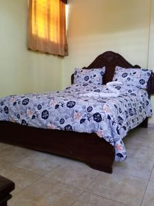 a bed with a blanket and pillows on it at Hotel Victoriano in San Felipe de Puerto Plata +14 photos