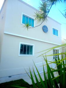 un bâtiment blanc avec des fenêtres et une horloge. dans l'établissement Hostel Borogodó, à Fortaleza