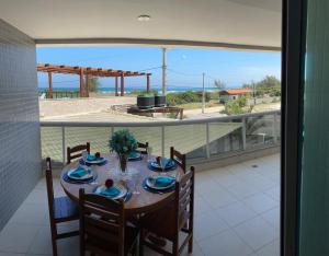 a dining room table with a view of the ocean at Arraial do cabo in Arraial do Cabo