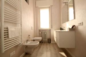 Residenza Bonomi 23 في مانتوفا: حمام أبيض مع حوض ومرحاض
