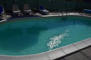 einen großen Pool mit Stühlen und einem Pool in der Unterkunft Savršen odmor u Villa Ivona in Zadar