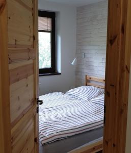1 dormitorio con 1 cama y puerta de madera en Apartment No.35 en Vysoke Tatry - Horny Smokovec