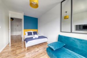 una camera con un letto e un divano blu di Apartment Virtuose - Disneyland Paris 5min - Train station 250m a Montévrain