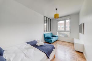 una camera con letto e sedia blu di Apartment Virtuose - Disneyland Paris 5min - Train station 250m a Montévrain
